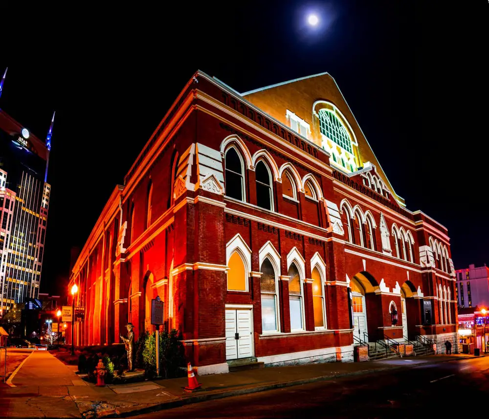 Exterior view of the Ryman Auditorium, a historic music venue in Nashville, Tennessee, known for its iconic red brick facade and distinctive architecture.