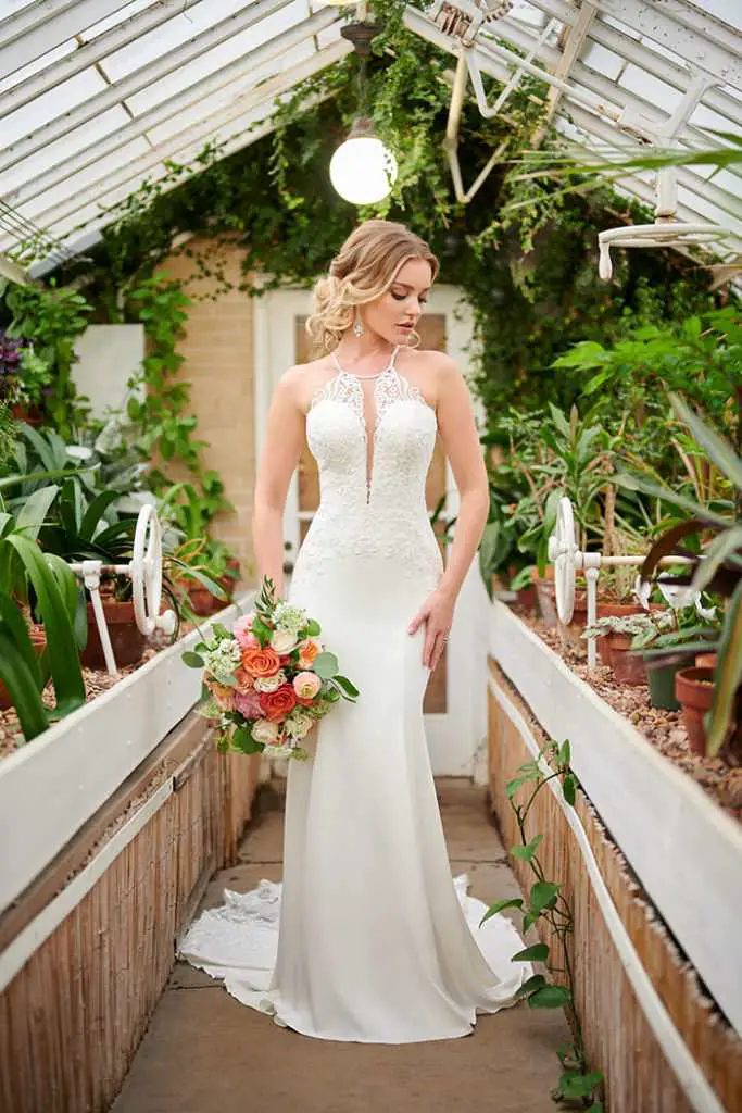 A woman wearing a sleek sheath dress, accentuated by stunning bouquet of flowers, radiating grace.